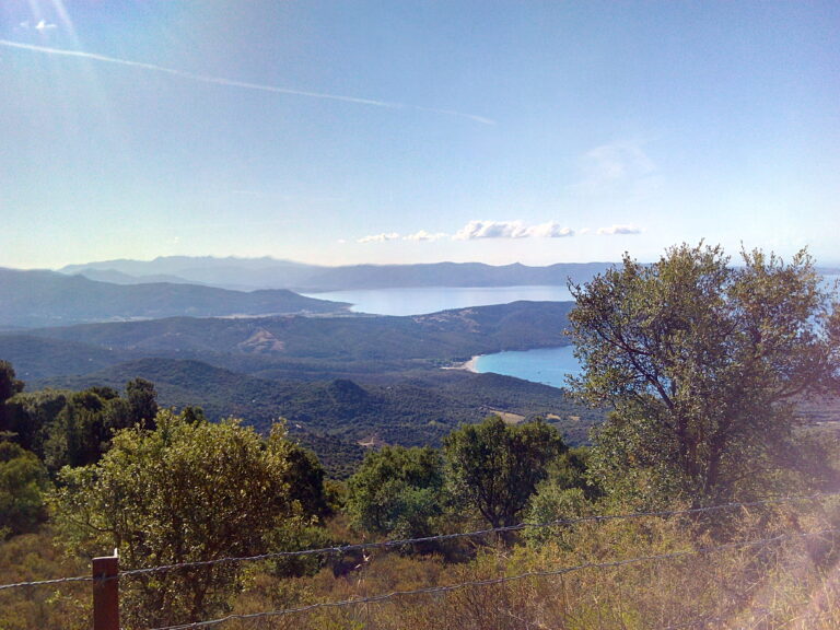 Photo de la mer pris d'un chemin en hauteurs en corse derrière un fil barbelé