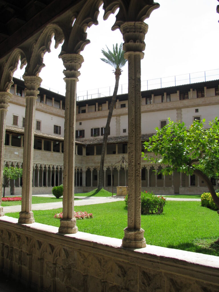 cloitre d'une abbaye à Majorque, avec un palmier au milieu