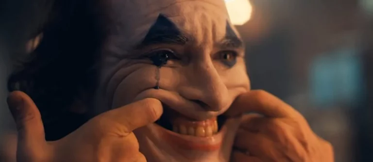 photo du joker qui force son sourire avec ses doigts