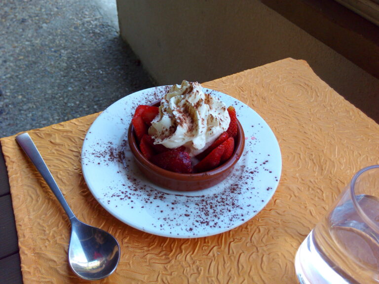 photo d'un dessert fait de fraise avec de la chantilly sur une tableau au restaurant