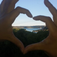 une personne qui fait un coeur avec ses mains sur un arrière plan du lac des gorges du Verdon
