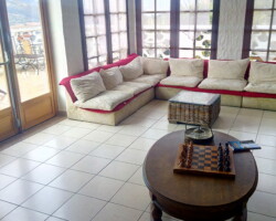une salle avec des fauteuils et une belle vue en Corse avec un jeu d'échec posé sur une table basse