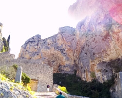 Photo en contre jour d'une personne qui monte un escalier en pierre en pente douce entre les montagnes